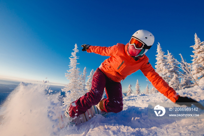 Snowboarder on snowboard rides through snow, explosion. Freeride snowboarding in Sheregesh Ski Resort