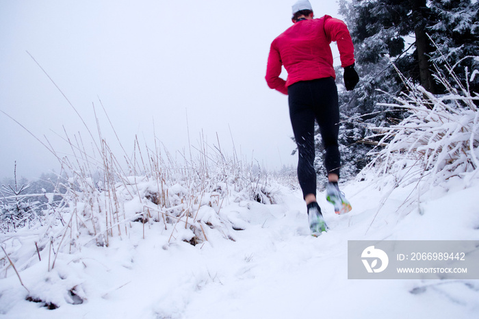 Läufer mit roter Jacke im Schnee, Running im Schnee, Laufen im Winter, trailrunning