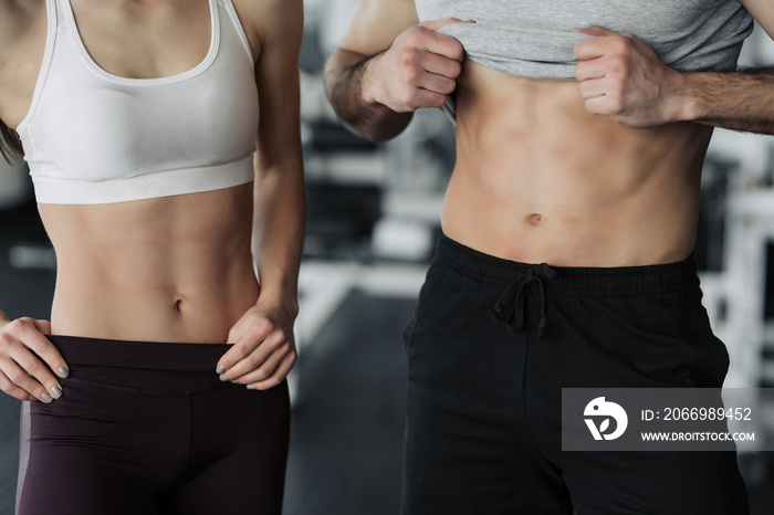 Fit woman and man showing her perfect abs