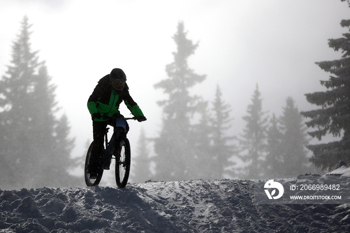 Cyclist extreme riding mountain bicycle in snow