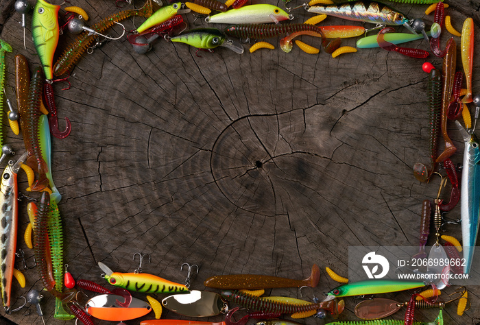 Frame of fishing tackle - net, fishing rod, fishing line, hooks and baits on a wooden background. Top view, copy space. Concept of hunting and fishing