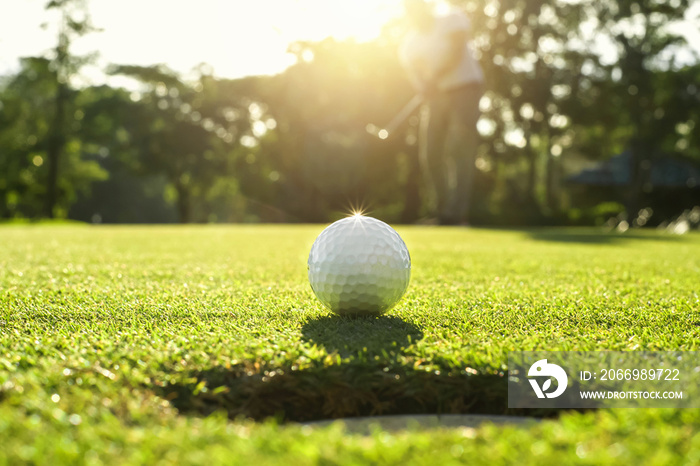 golf player putting golf ball into hole