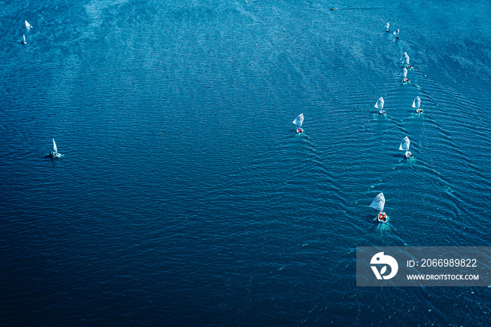 Regatta of small boats on blue lake in sunny day