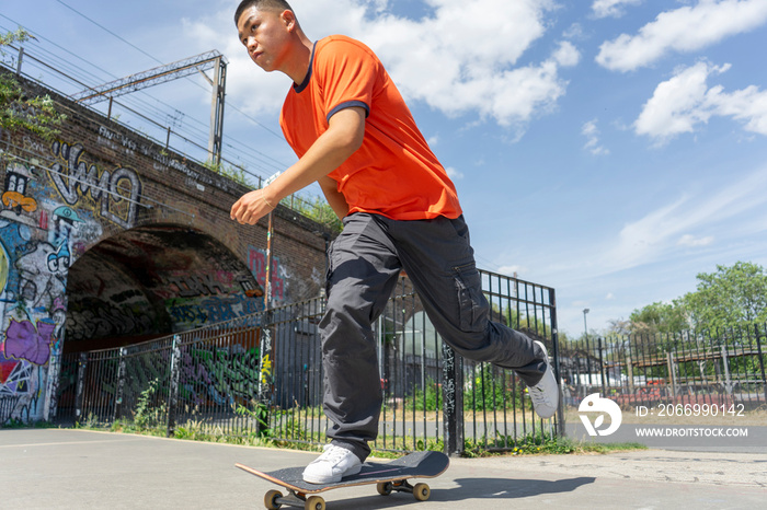 Young man skateboarding on footpath