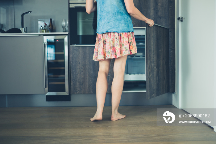 Woman opening freezer in kitchen