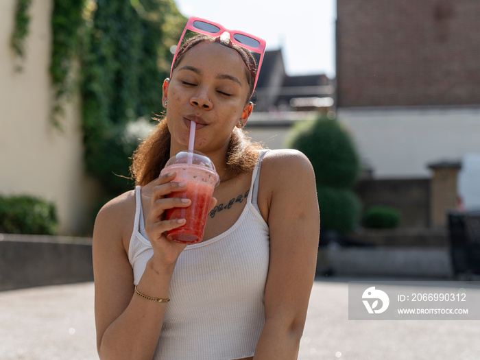 Portrait of young woman drinking smoothie