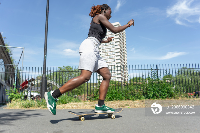 Young woman skateboarding in street