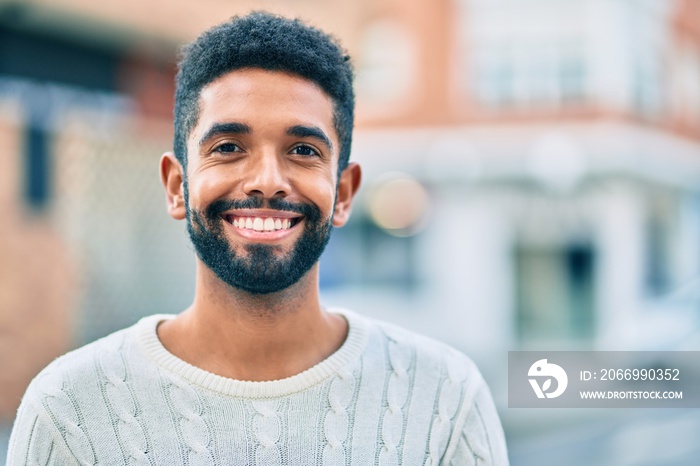 Young african american man smiling happy standing at the city.