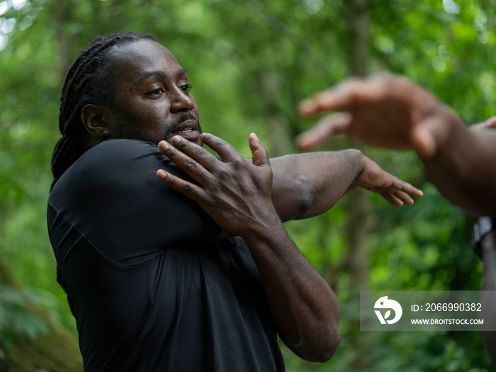 Man stretching after workout in forest