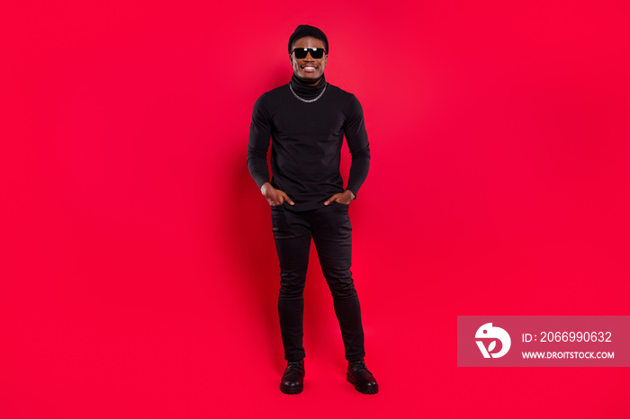 Full length body size view of attractive cheerful funky guy wearing black garment posing isolated over bright red color background