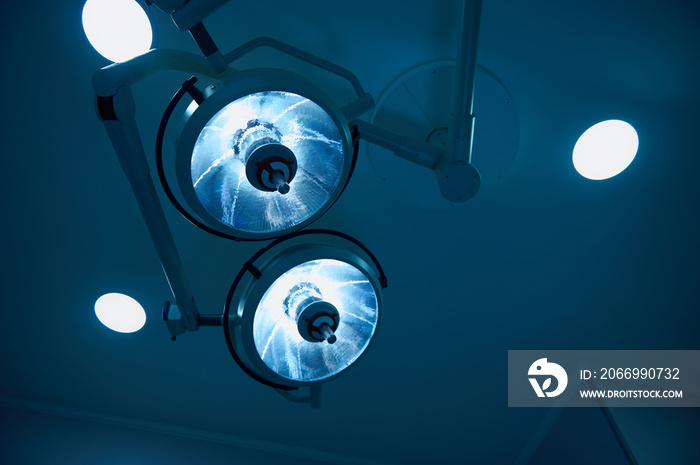 Bottom view to blue filter light, medical surgical electric lamp in modern operating room in hospital. Medical concept, copy space.