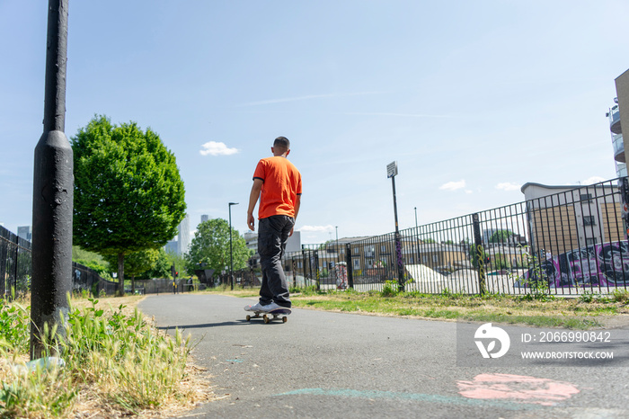 Young man skateboarding on footpath