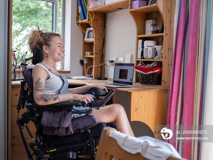 Smiling woman in electric wheelchair at home