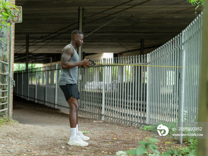 Man doing strength training with resistance band outdoors