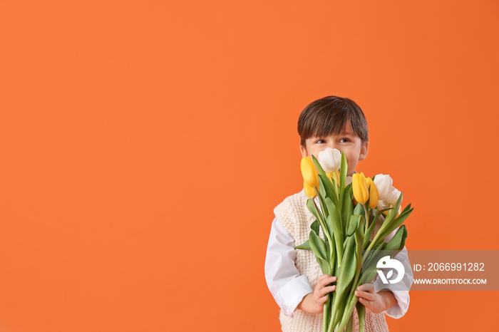 Cute little boy with spring flowers on color background