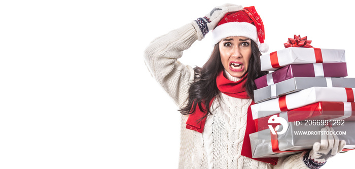 Woman in Santa’s cap and white seater on a white background holds Christmas presents going crazy from the seasonal rush