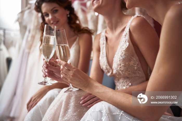 Close up of happy young brides with champagne