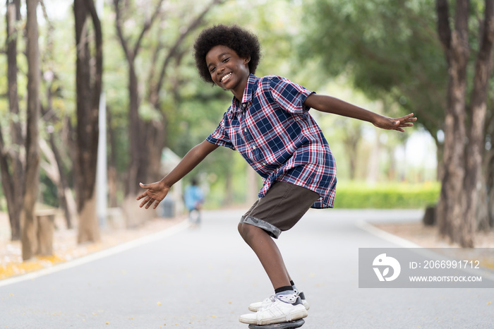 Boy playing on skateboard. African American boy riding skateboard in the road. Kid practicing skateboard.