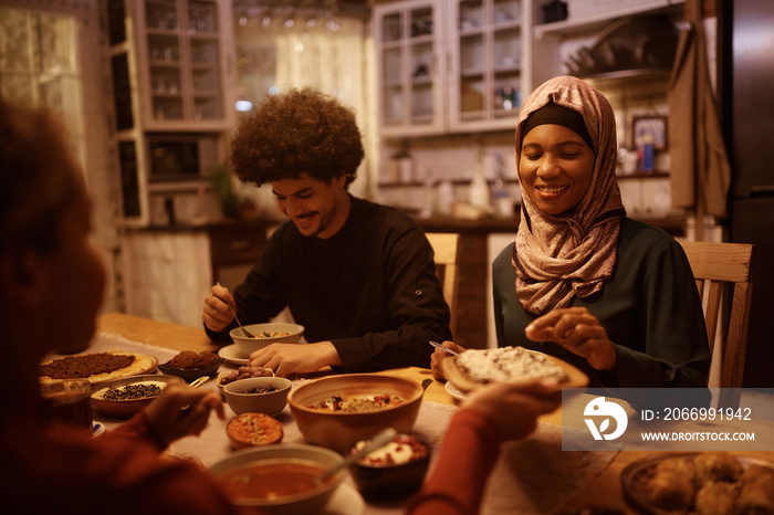 Happy Middle Eastern family enjoying in dinner at dining table.