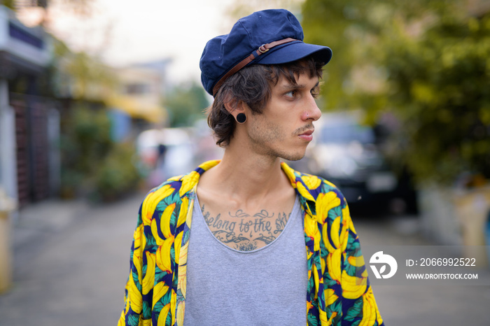 Closeup profile view of young rebellious man outdoors