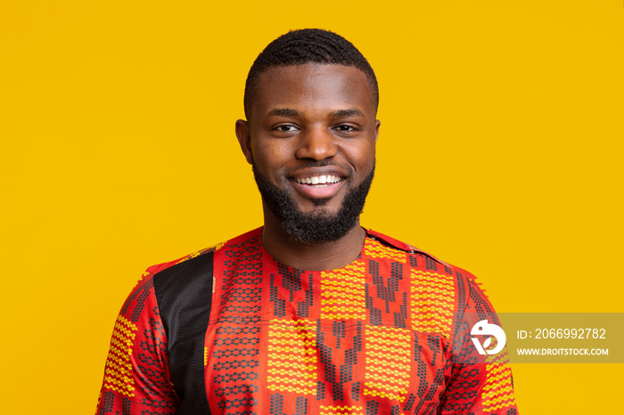 Portrait of handsome cheerful black guy in traditional clothes