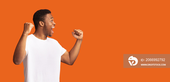 Afro man screaming over orange studio background
