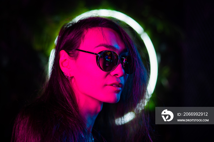 Portrait of asian man wearing sunglasses in neon light.