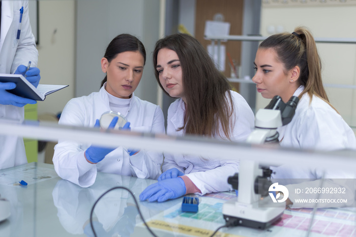 Group of  Laboratory scientists working at lab with test tubes, test or research in clinical laboratory.Science, chemistry, biology, medicine and people concept.