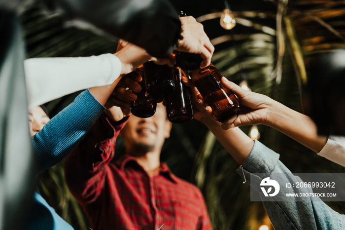 Group Asian people happy friends celebrating and clinking with bottles of beer