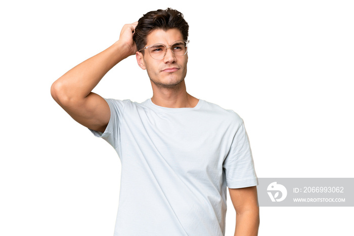 Young caucasian handsome man over isolated background having doubts while scratching head