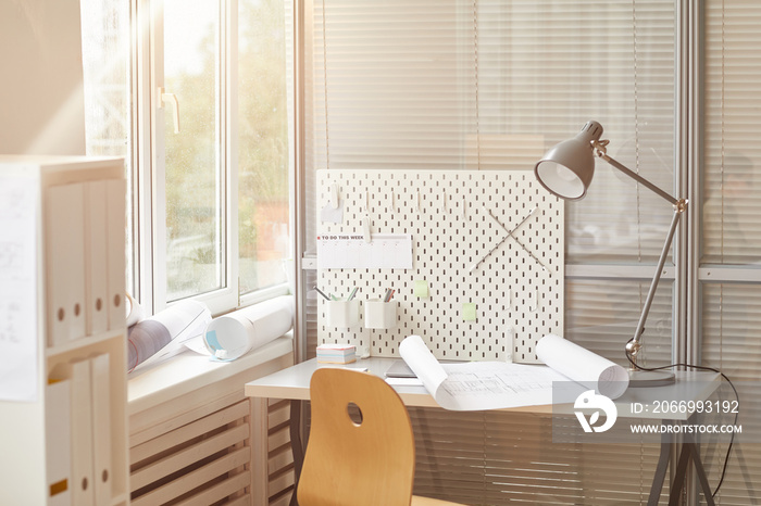 Warm-toned background image of engineers workplace lit by sunlight, copy space