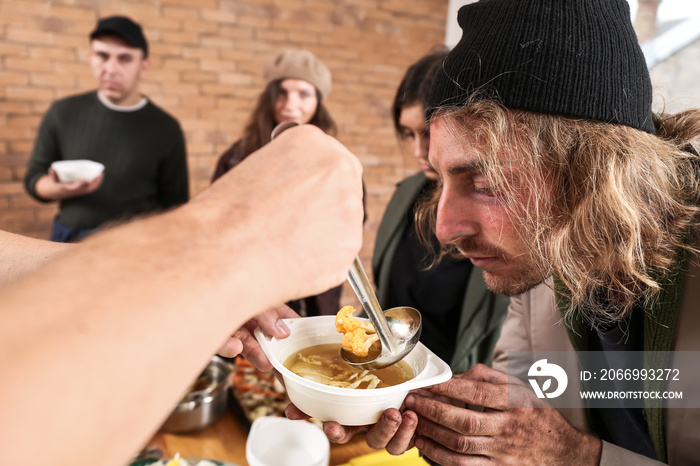 Volunteers giving food to homeless people