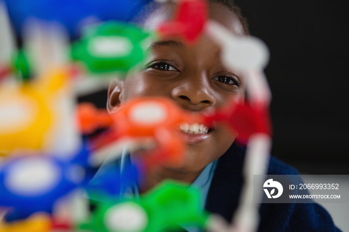 Schoolgirl experimenting molecule model against black background