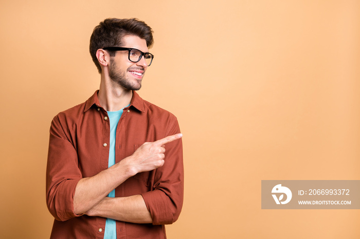 Close-up portrait of his he nice attractive cheerful cheery glad content brunet guy pointing forefinger aside copy space advice advert ad decision isolated over beige color pastel background