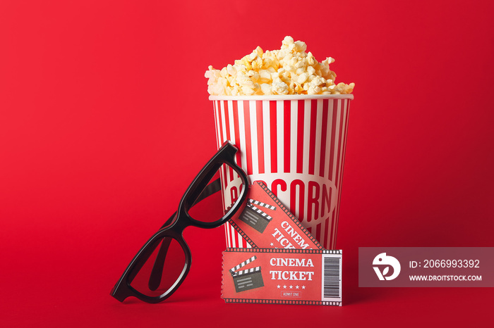 Bucket with tasty popcorn, 3D glasses and cinema tickets on color background