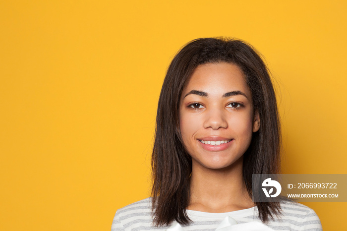 Portrait of smiling African American woman on yellow background