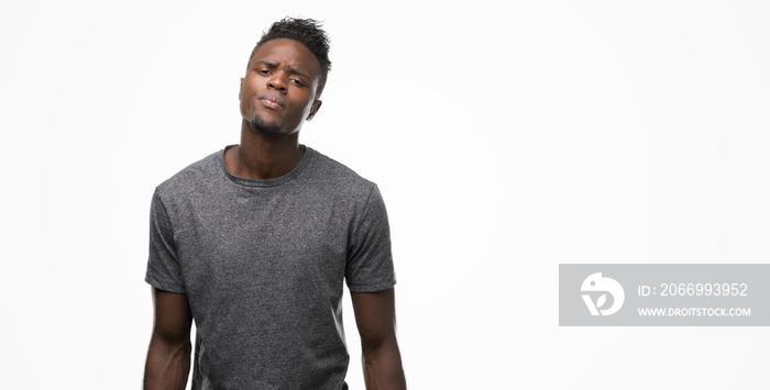 Young african american man wearing grey t-shirt skeptic and nervous, disapproving expression on face with crossed arms. Negative person.