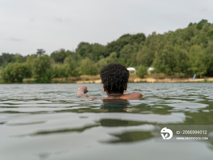 Young man swimming in lake