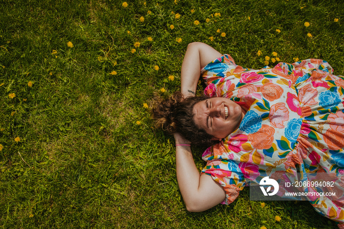 woman lies on grass eyes closed