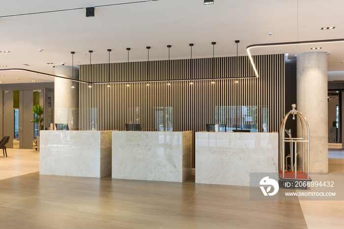 Interior of a hotel lobby with reception desks with transparent covid plexiglass lexan clear sneeze guards