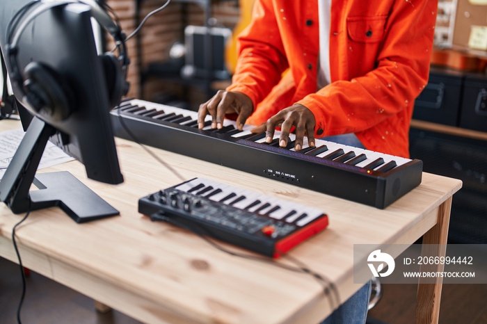 African american man musician playing piano keyboard at music studio