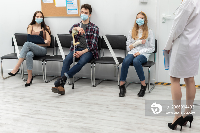 The doctor reads out the next person in line. During a pandemic everyone must wear protective masks