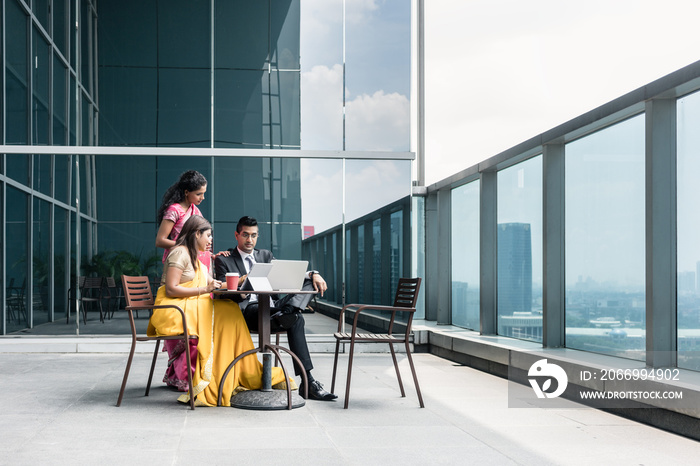 Three Indian business people with worried facial expression talking during break at work