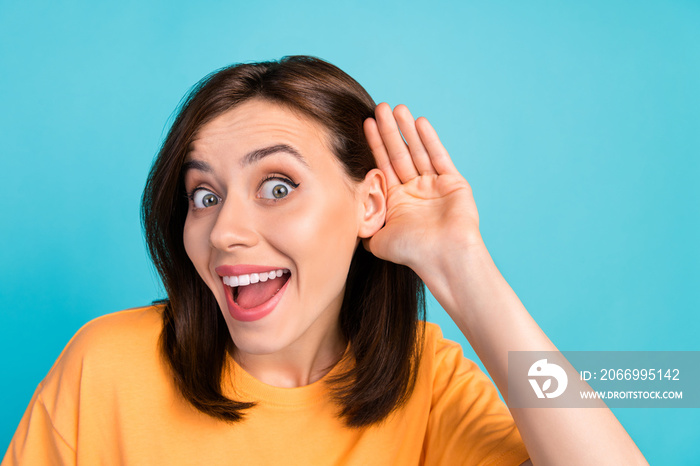 Portrait of shocked pretty lady arm near ear listen hear interested isolated on blue color background