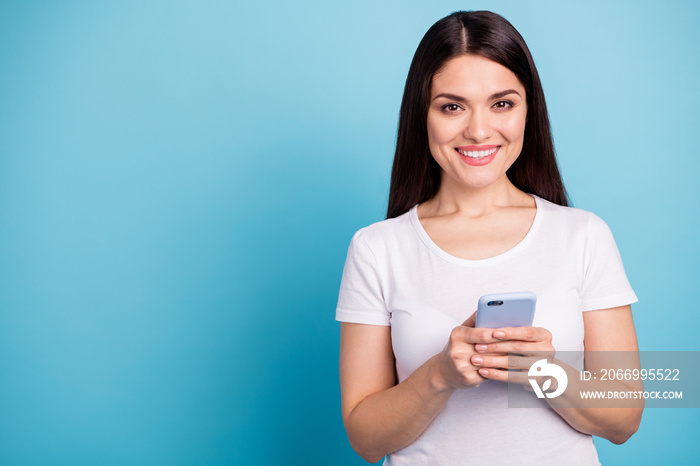 Photo of nice cute cheerful amazing woman toothily smiling holding her telephone while isolated with blue background