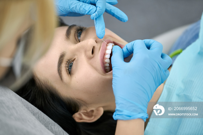 Pretty woman’s teeth cleaning in dental clinic