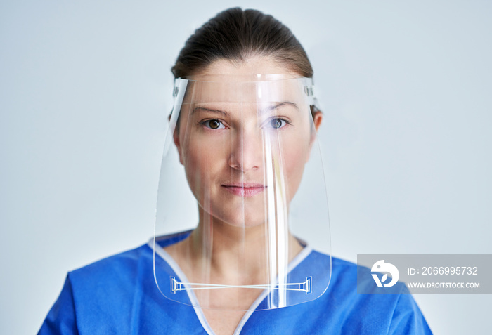 Close up portrait of female medical doctor or nurse wearing face shield