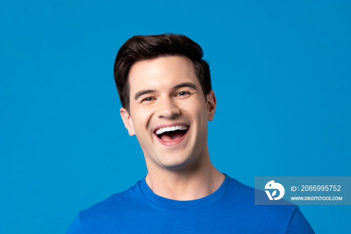 Young friendly caucasian man in plain blue t-shirt laughing