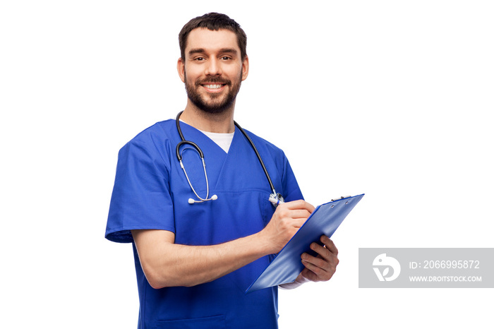 healthcare, profession and medicine concept - happy smiling doctor or male nurse in blue uniform writing medical report on clipboard over white background