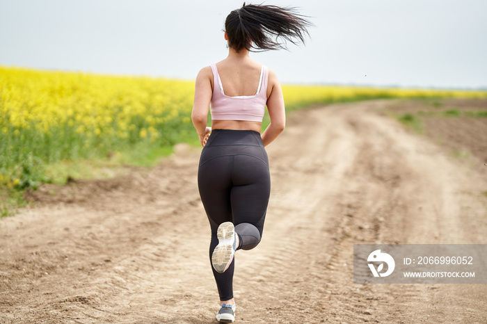 Plus size woman running on a countryside dirt road